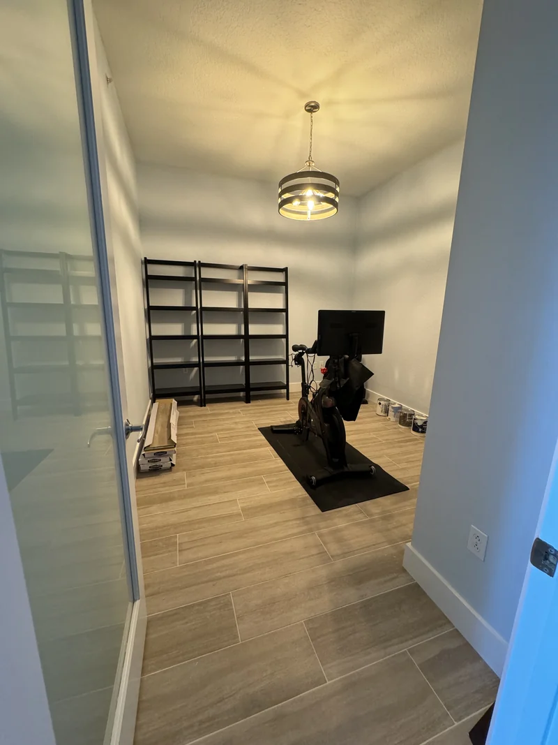 Guest room with wood-look tile flooring and a sliding glass-panel door