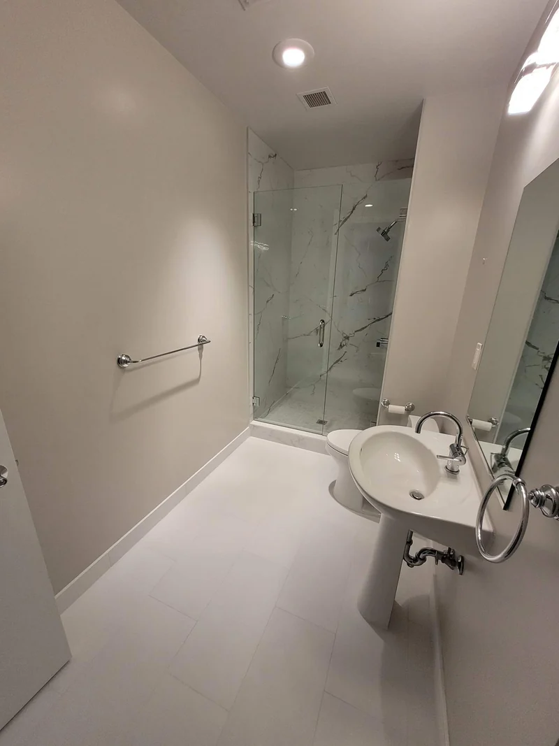 Wall-mounted basin and a bathtub with white veined wall tile